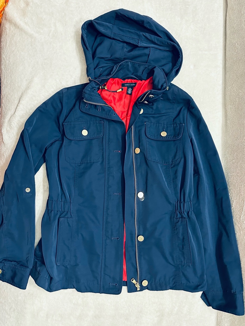 Tommy Hilfiger hooded jacket features a vibrant red interior lining